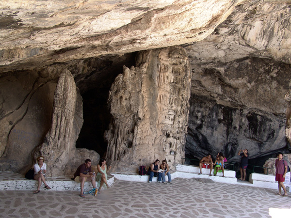 La célèbre grotte d'Antiparos est un point fort de toute visite de l'île soeur de Paros. On s'y rend en prenant le petit bac qui relie Pounta (côte ouest de Paros) au port d'Antiparos, puis en suivant la route côtière menant à Aghios Georgios sur 6km avant de prendre une route qui monte à droite sur environ 2km.<p>La grotte est très bien aménagée pour la visite et c'est un excellent moyen d'échapper un moment à la canicule au plus chaud de l'été! A l'entrée, une monstrueuse stalagmite serait, avec ses 45 millions d'années, la plus vieille d'Europe. Attention: la grotte comprend 3 salles et on descend à plus de 100m de profondeur, si vous avez peur des escaliers abstenez-vous!<p>La grotte a connu la gloire dès le XVIIe siècle: un marquis français y descendit avec une suite de 500 personnes pour y célébrer la messe de minuit, le 24 décembre 1673... Abstenez-vous toutefois de faire des graffiti comme les nobles visiteurs des temps anciens, contentez-vous de vous amuser à les déchiffrer!