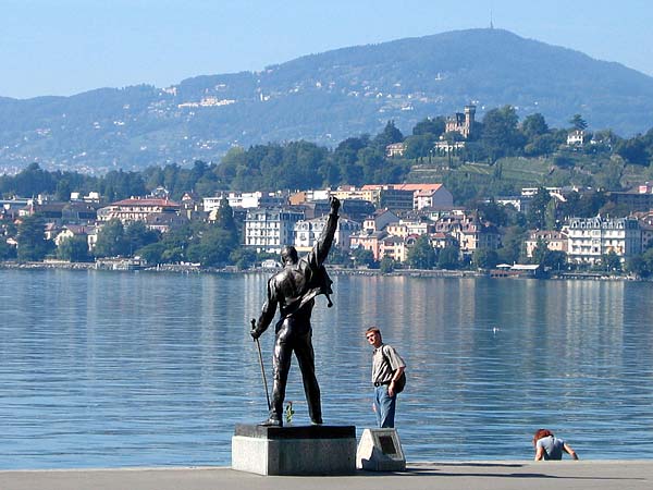 La statue de Freddie Mercury, sur les quais de Montreux, avec le Château des Crêtes et le Mont-Pèlerin à l'arrière-plan.